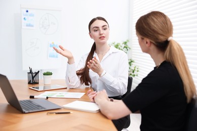 Photo of Business coach working with woman at wooden table in office