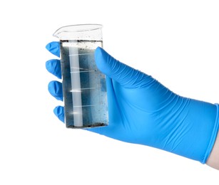 Photo of Scientist holding beaker with dirty water on white background, closeup