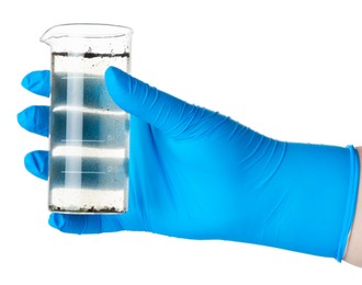 Photo of Scientist holding beaker with dirty water on white background, closeup