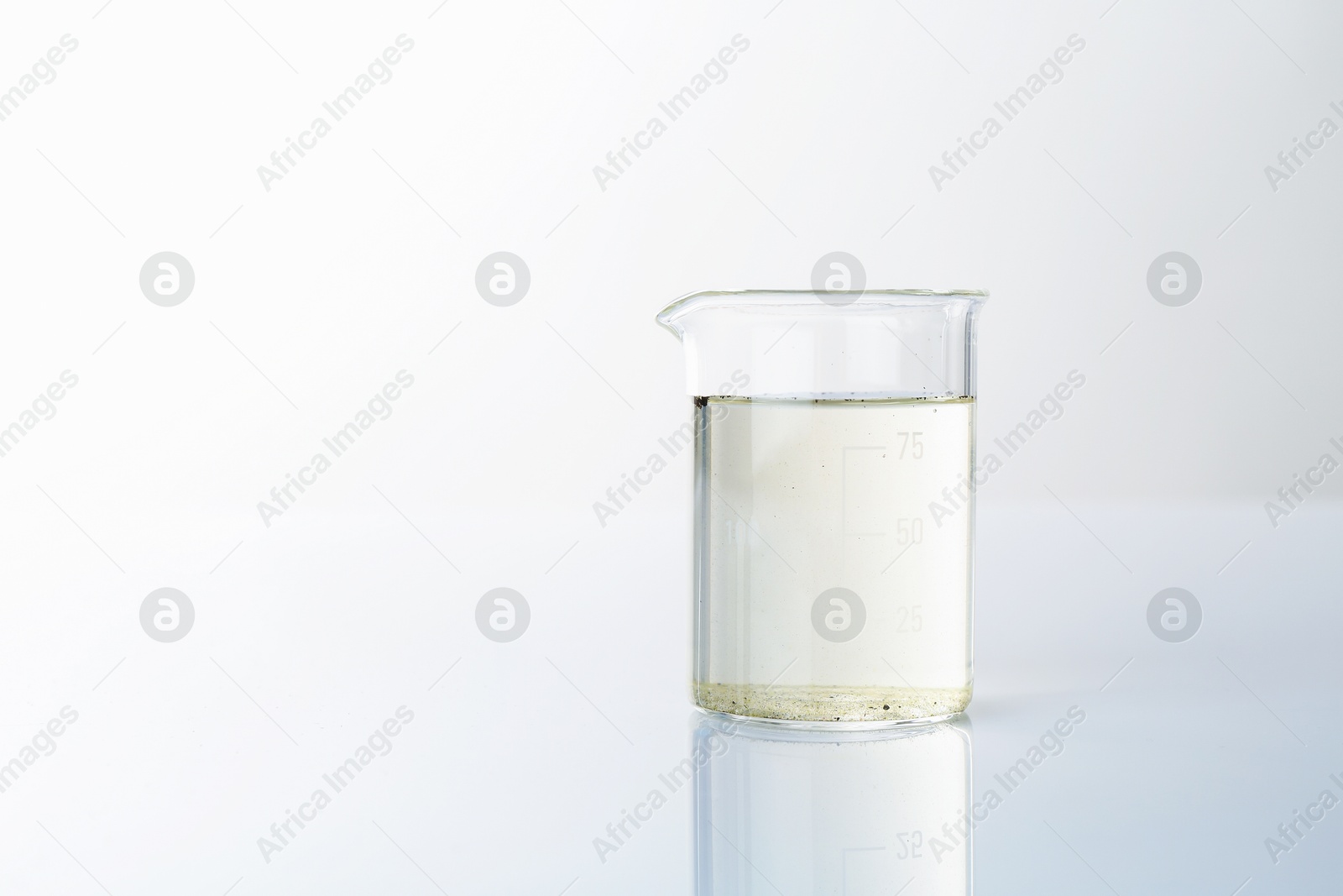 Glass beaker with dirty water on mirror surface, space for text Photo of Glass beaker with dirty water on mirror surface, space for text