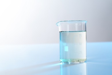 Photo of Glass beaker with dirty water on mirror surface, space for text