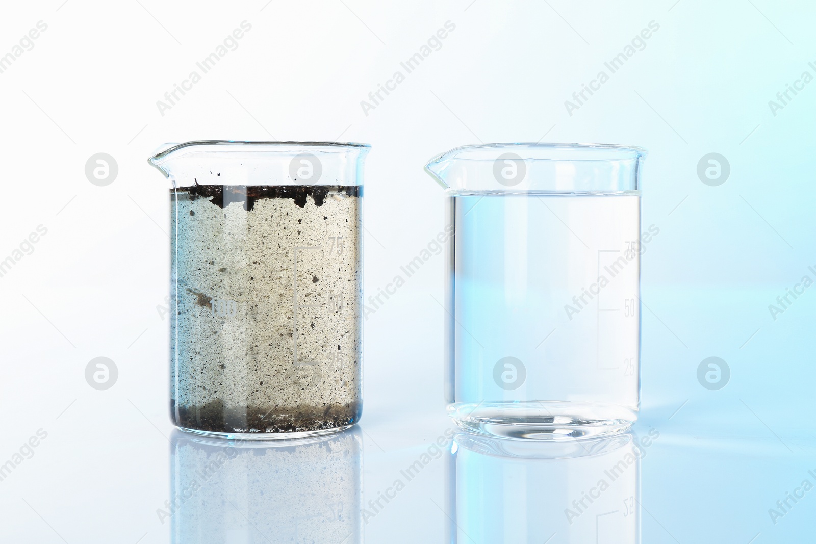 Photo of Glass beakers with clean and dirty water on mirror surface