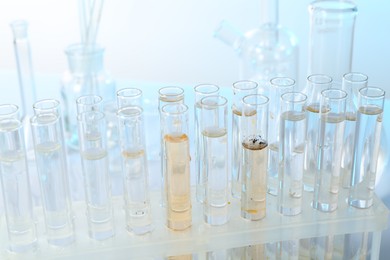 Photo of Glass test tubes with clean and dirty water on blurred background, closeup
