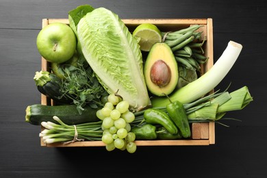 Photo of Superfood. Healthy food products in crate on black wooden table, top view