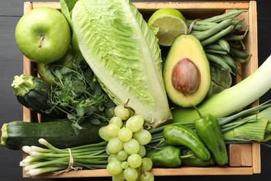 Photo of Superfood. Healthy food products in crate on black wooden table, top view