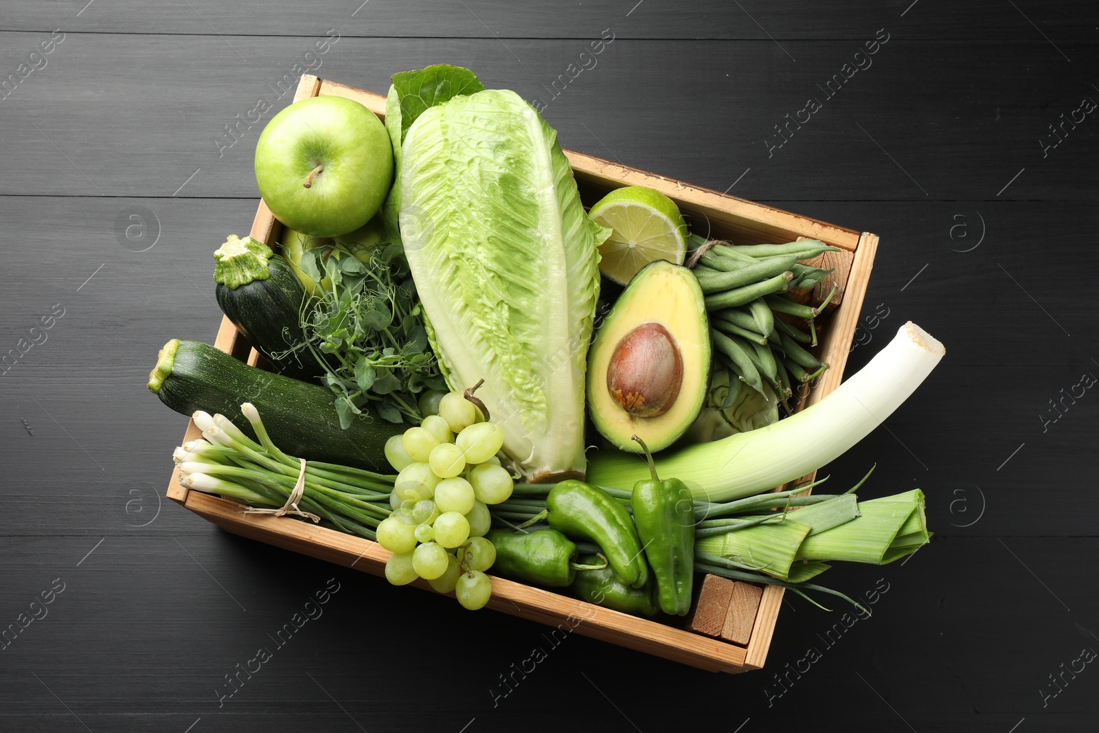 Photo of Superfood. Healthy food products in crate on black wooden table, top view