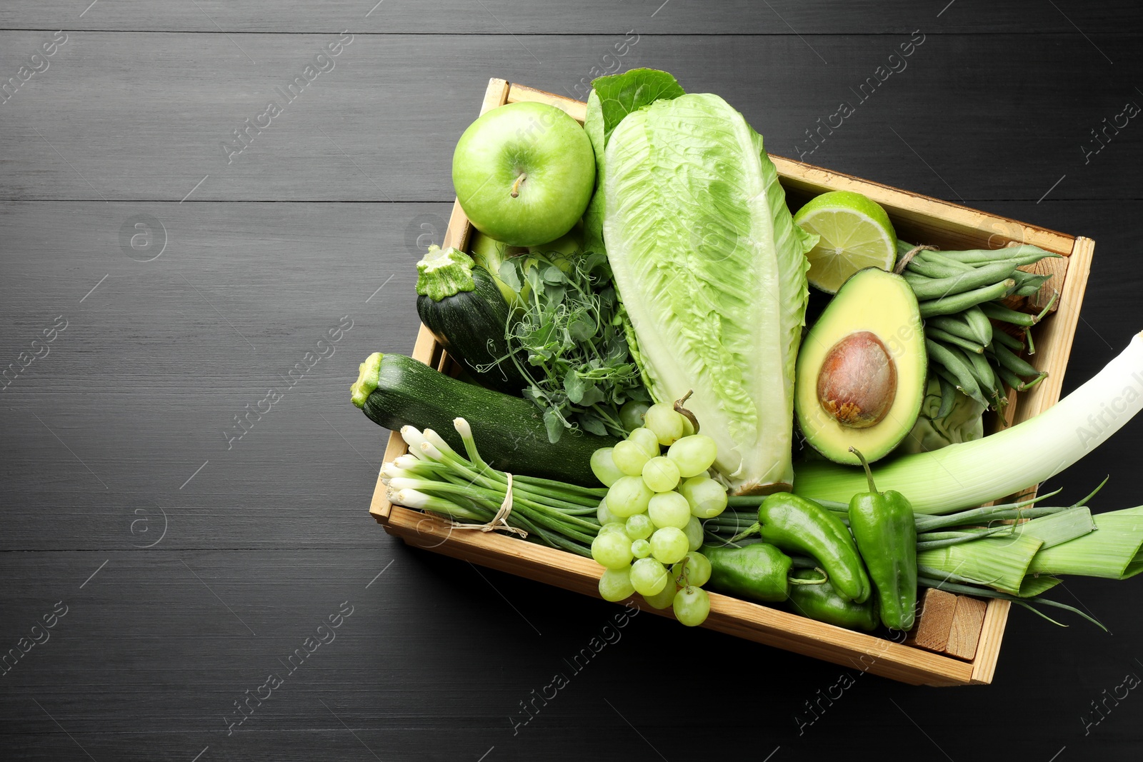 Photo of Superfood. Healthy food products in crate on black wooden table, top view. Space for text