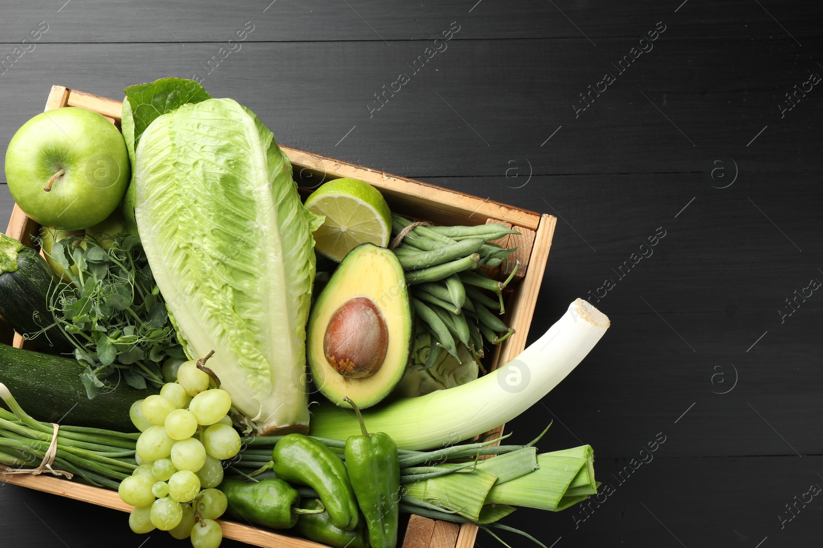Photo of Superfood. Healthy food products in crate on black wooden table, top view. Space for text