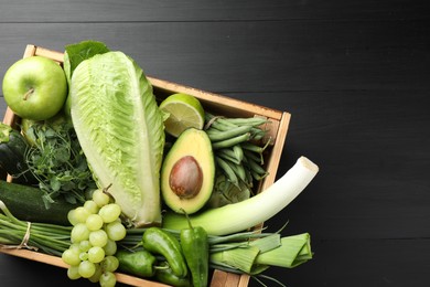 Photo of Superfood. Healthy food products in crate on black wooden table, top view. Space for text