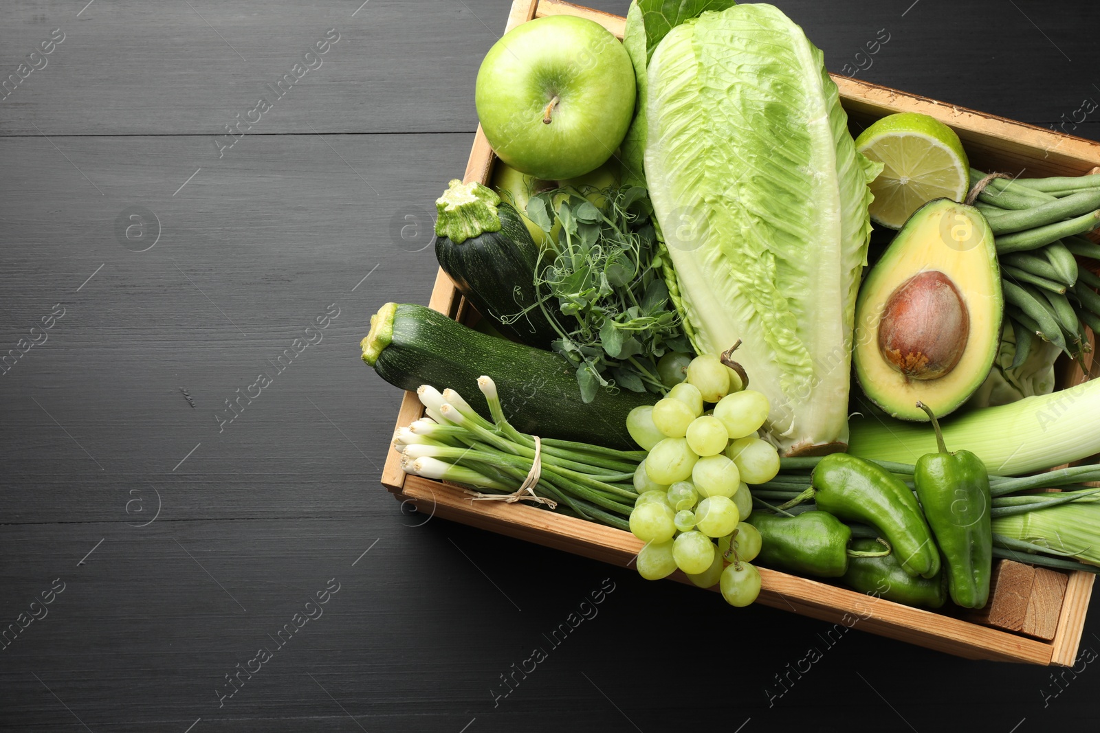 Photo of Superfood. Healthy food products in crate on black wooden table, top view. Space for text
