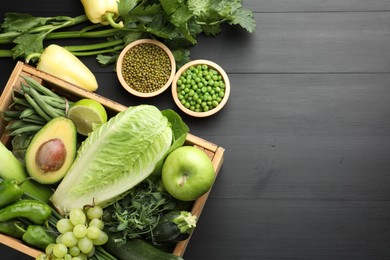 Photo of Superfood. Healthy food products on black wooden table, flat lay. Space for text