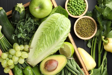 Photo of Superfood. Healthy food products on black wooden table, flat lay