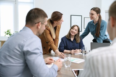 Photo of Business coach working with group of people in office