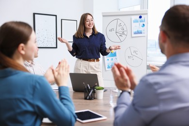 Photo of Business coach giving presentation to group of people in office