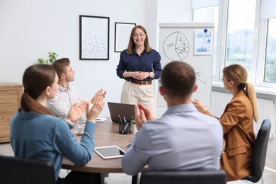 Photo of Business coach giving presentation to group of people in office