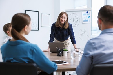 Photo of Business coach giving presentation to group of people in office
