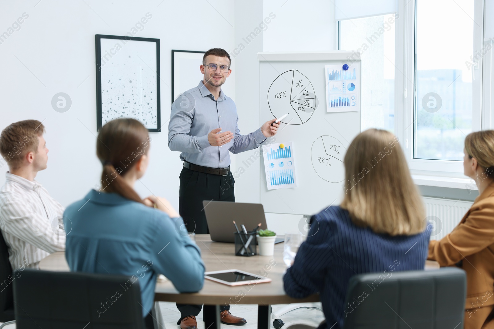 Business coach giving presentation to group of people in office Photo of Business coach giving presentation to group of people in office