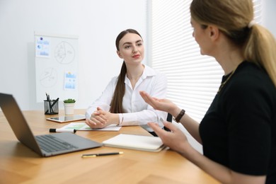 Photo of Business coach working with woman at wooden table in office