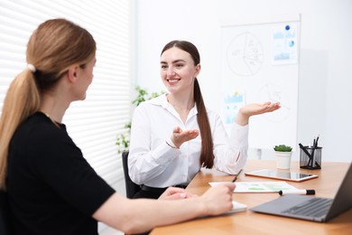 Photo of Business coach working with woman at wooden table in office