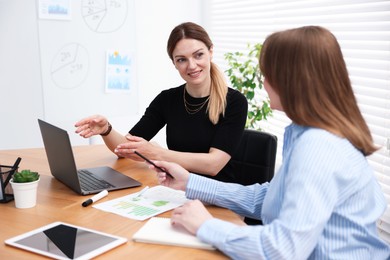 Photo of Business coach working with woman at wooden table in office