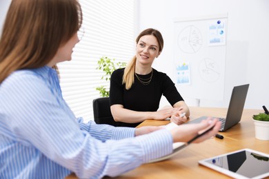 Photo of Business coach working with woman at wooden table in office