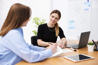 Photo of Business coach working with woman at wooden table in office