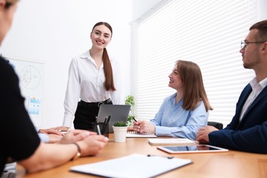Photo of Business coach giving presentation to group of people in office