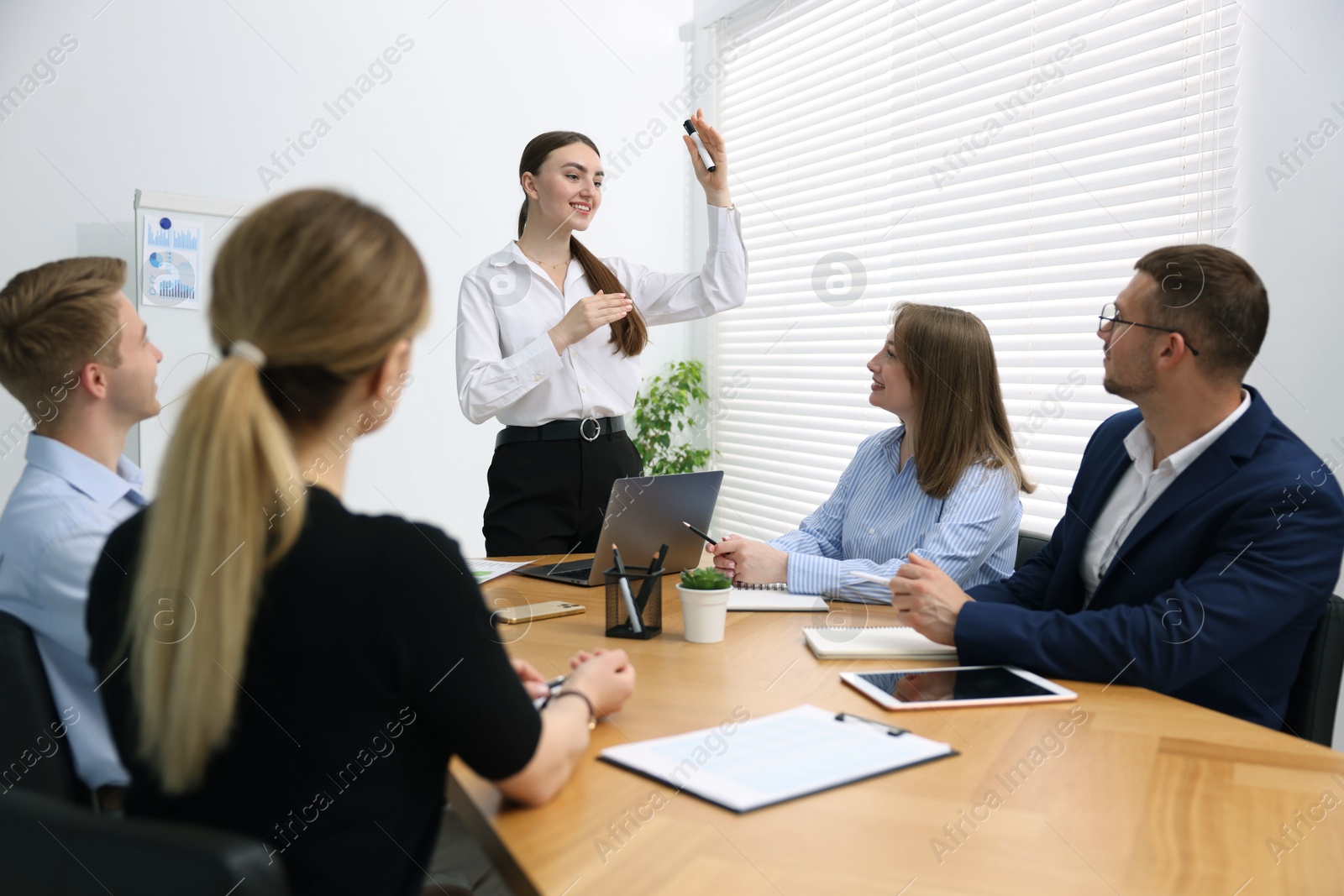 Business coach giving presentation to group of people in office Photo of Business coach giving presentation to group of people in office