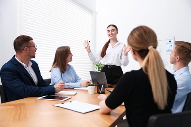 Photo of Business coach giving presentation to group of people in office