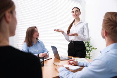 Photo of Business coach giving presentation to group of people in office