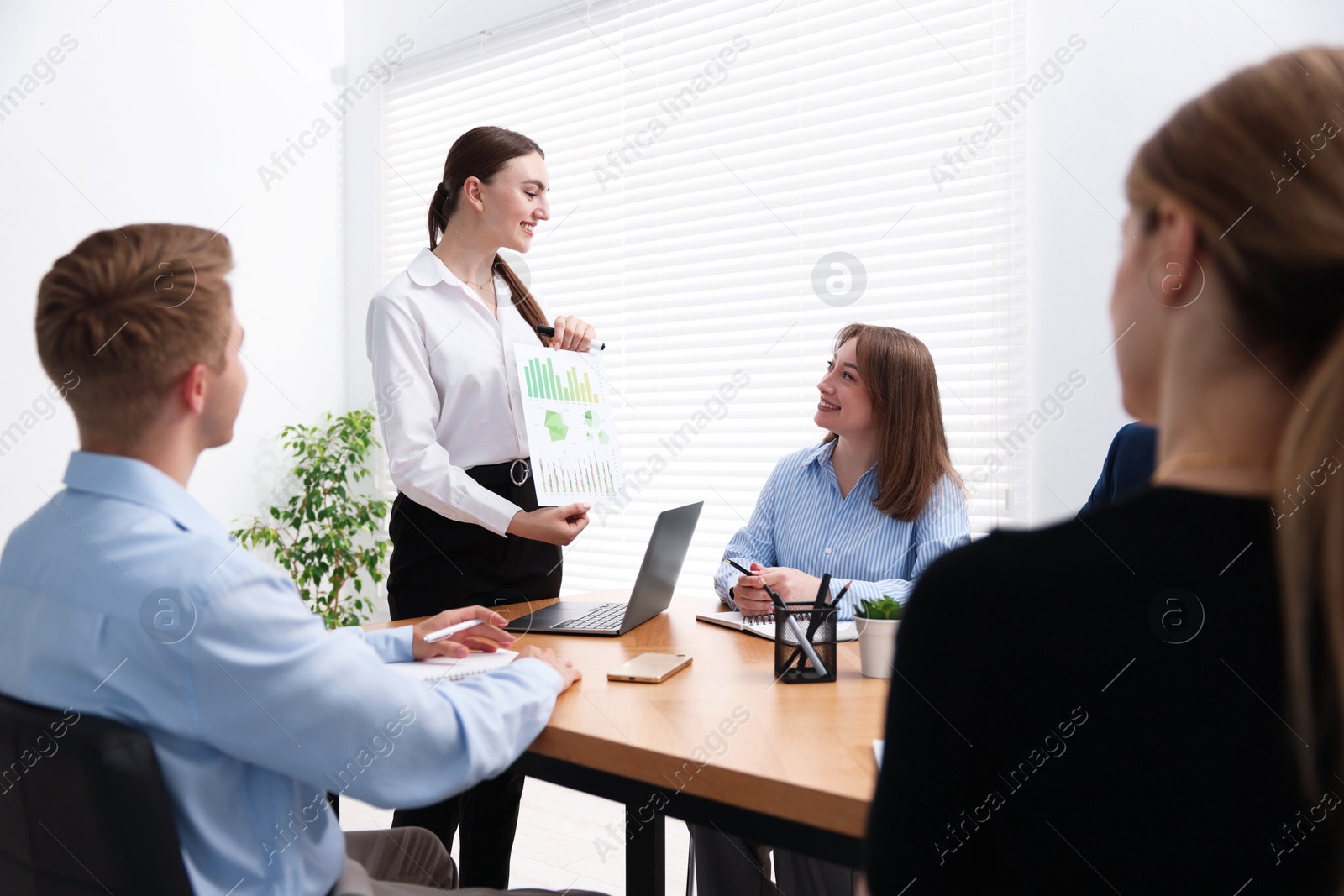 Business coach giving presentation to group of people in office Photo of Business coach giving presentation to group of people in office