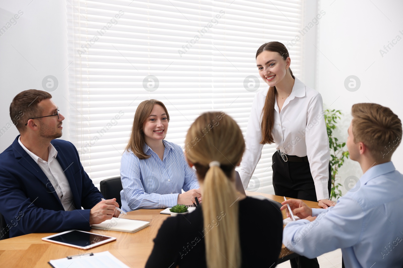 Business coach giving presentation to group of people in office Photo of Business coach giving presentation to group of people in office