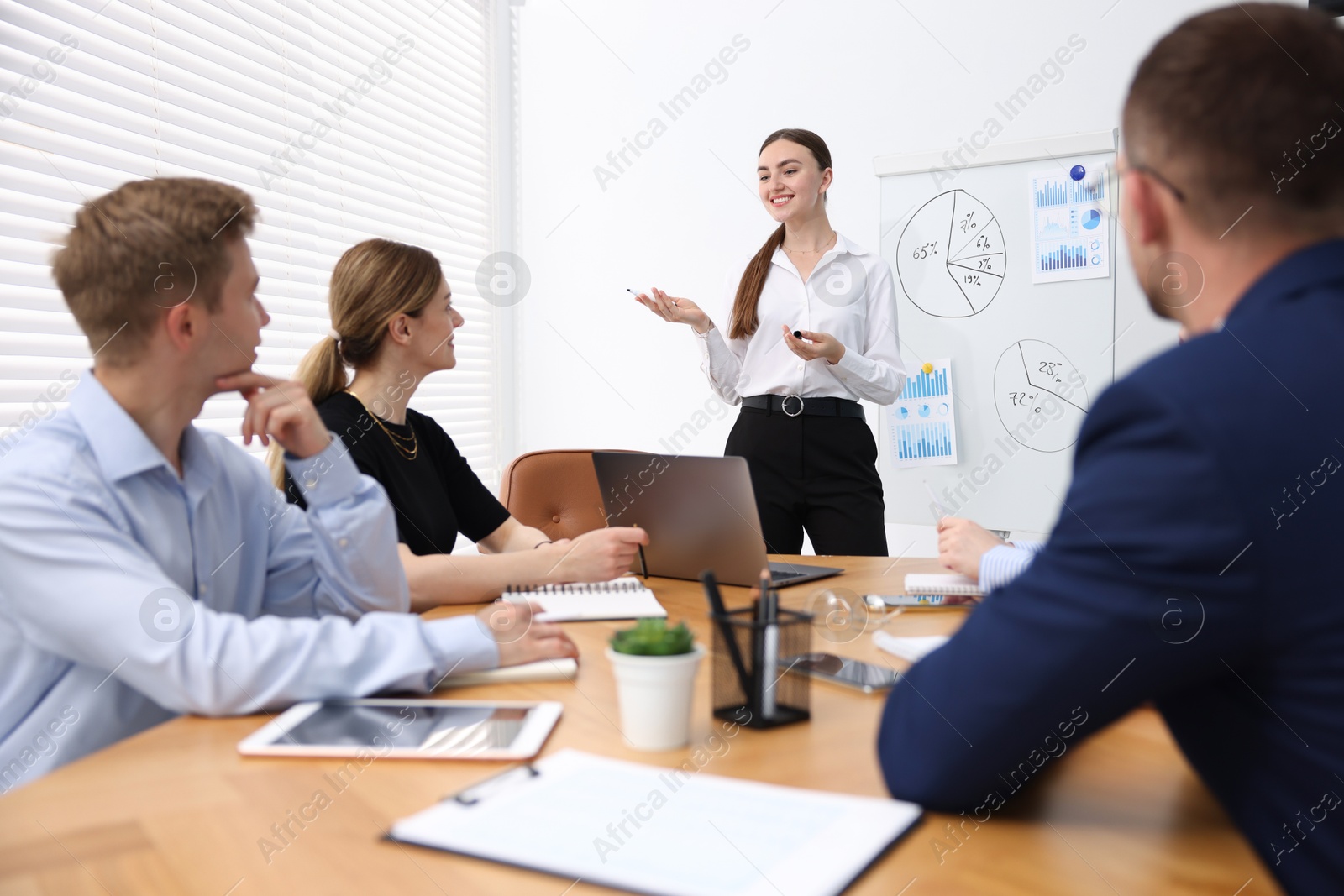 Business coach giving presentation to group of people in office Photo of Business coach giving presentation to group of people in office