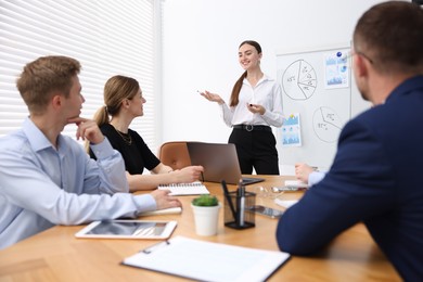 Photo of Business coach giving presentation to group of people in office
