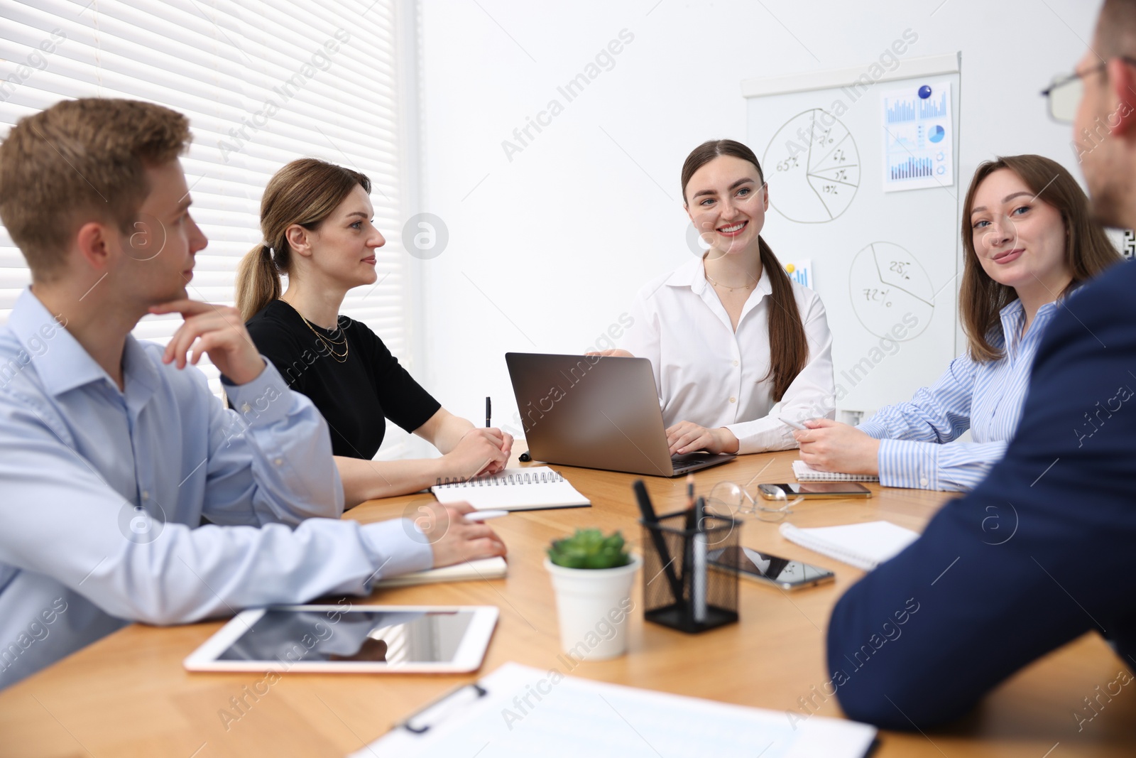 Business coach giving presentation to group of people in office Photo of Business coach giving presentation to group of people in office