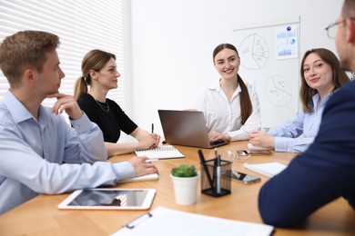 Photo of Business coach giving presentation to group of people in office