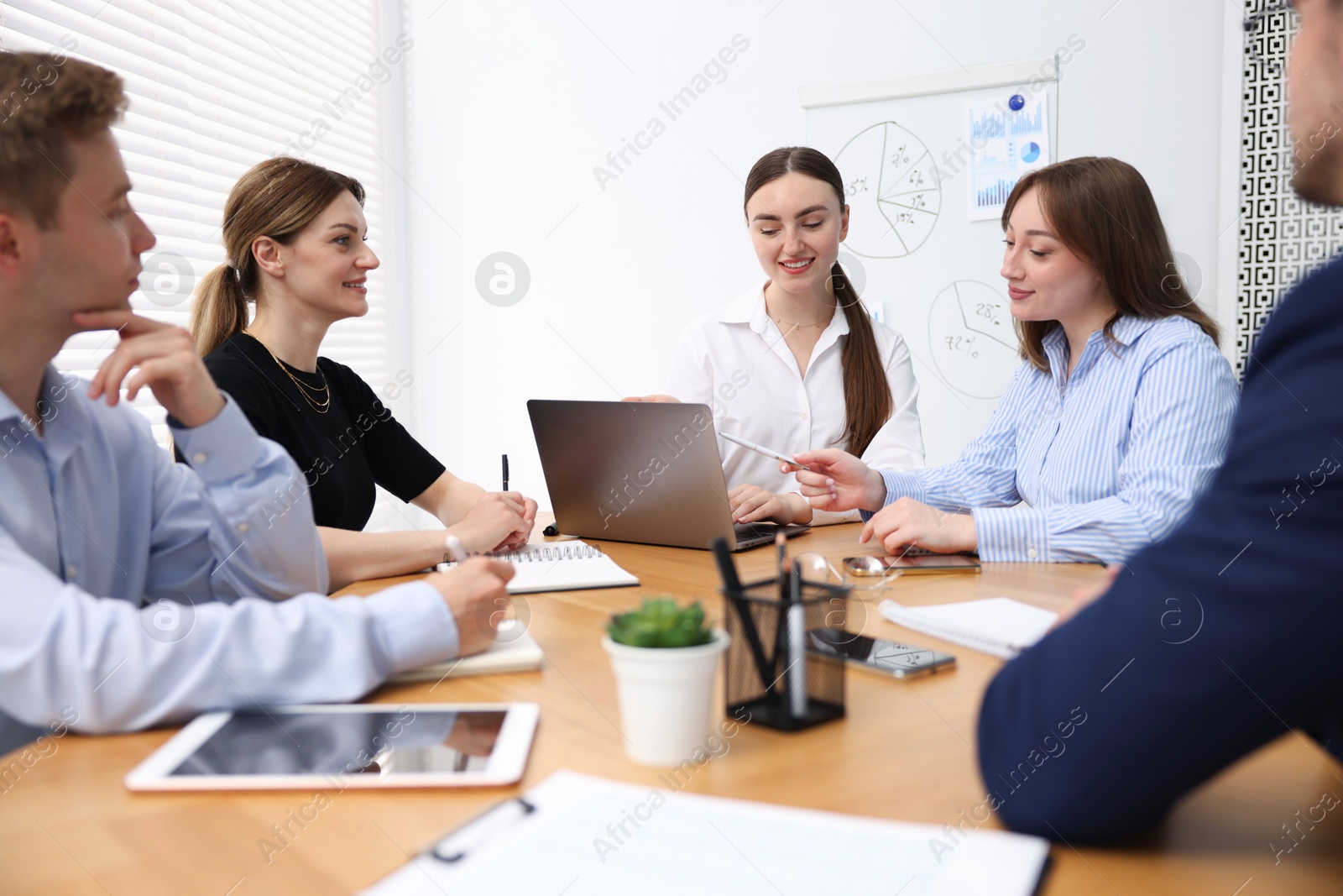 Business coach giving presentation to group of people in office Photo of Business coach giving presentation to group of people in office