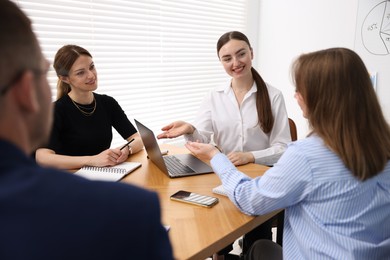 Photo of Business coach giving presentation to group of people in office