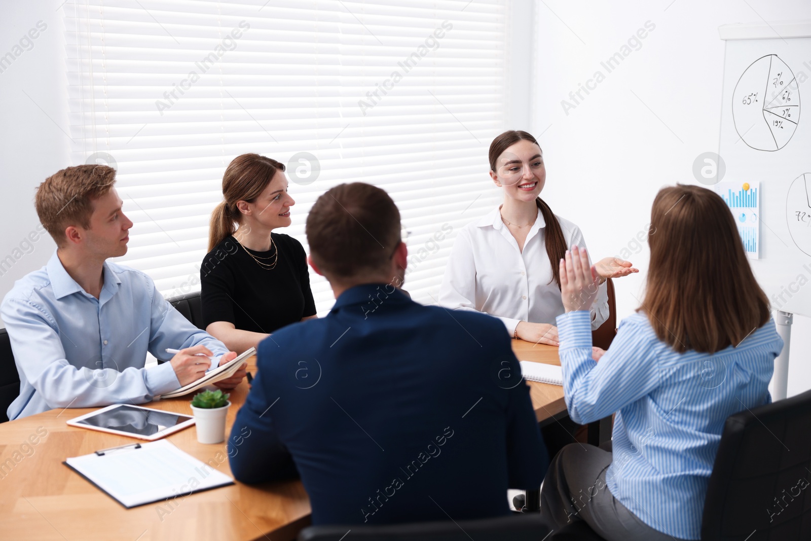 Business coach giving presentation to group of people in office Photo of Business coach giving presentation to group of people in office