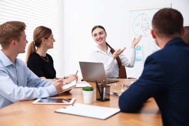 Photo of Business coach giving presentation to group of people in office