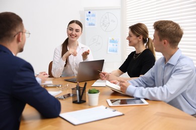 Photo of Business coach giving presentation to group of people in office