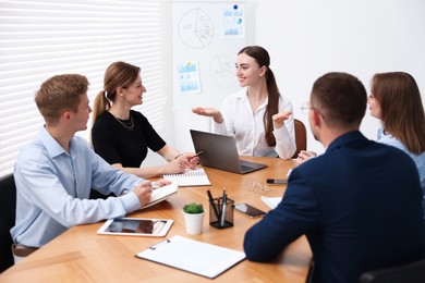 Photo of Business coach giving presentation to group of people in office