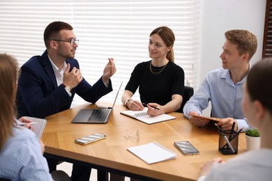 Photo of Business coach working with group of people in office