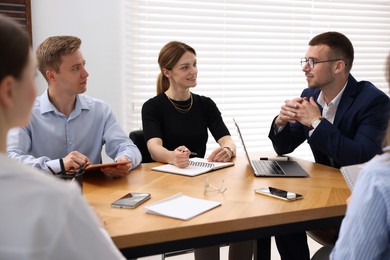 Photo of Business coach working with group of people in office