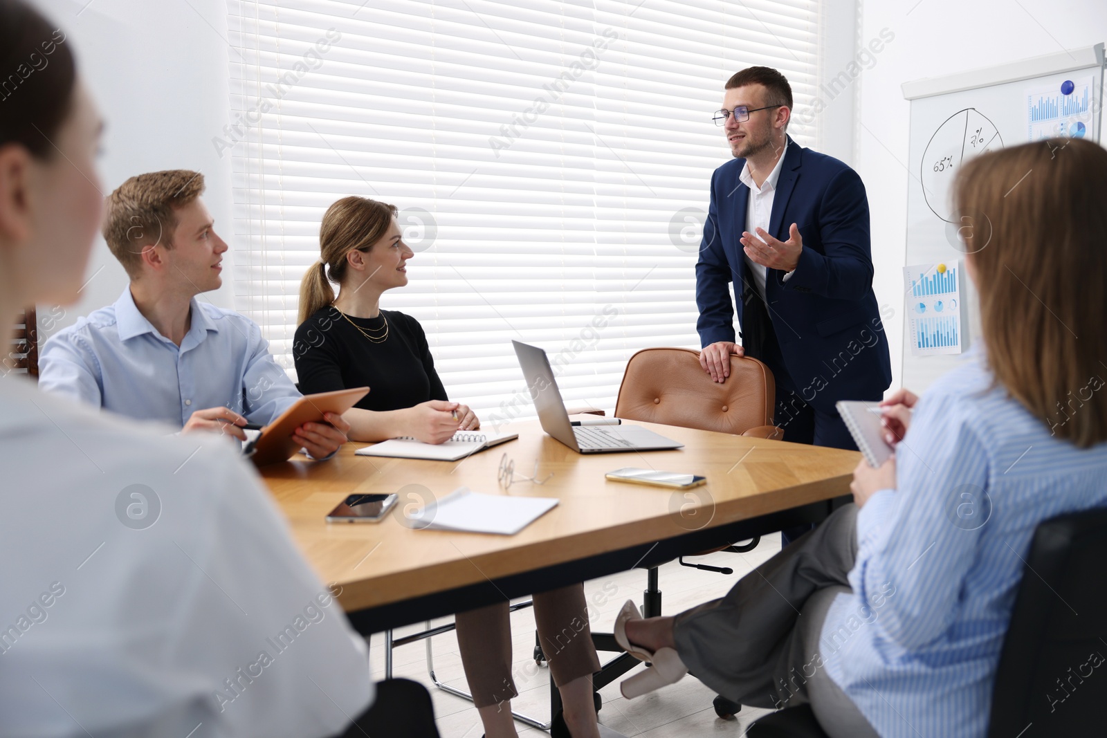 Business coach giving presentation to group of people in office Photo of Business coach giving presentation to group of people in office