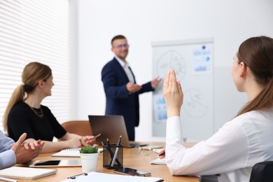 Photo of Business coach giving presentation to group of people in office, selective focus