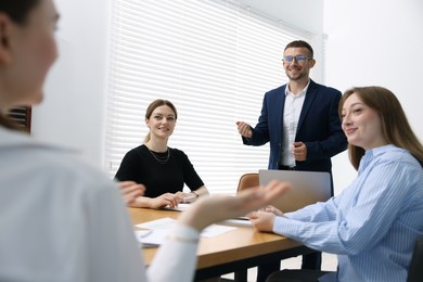 Photo of Business coach giving presentation to group of people in office
