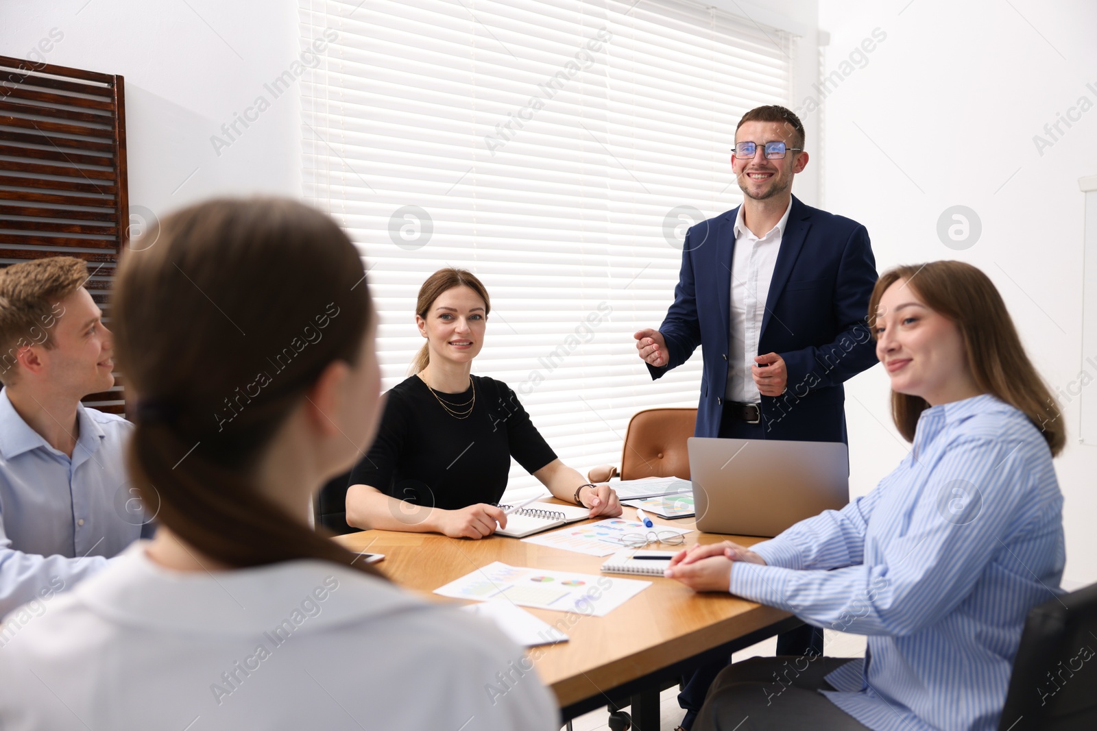 Business coach giving presentation to group of people in office Photo of Business coach giving presentation to group of people in office