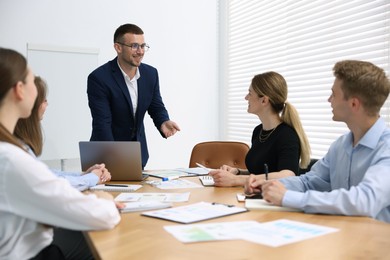 Photo of Business coach giving presentation to group of people in office