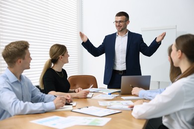 Photo of Business coach giving presentation to group of people in office